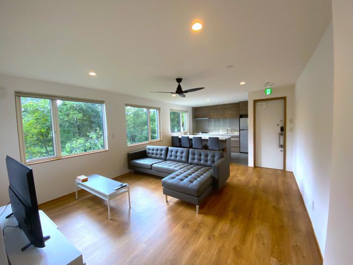 A black lounge suite in a white room with wooden floors