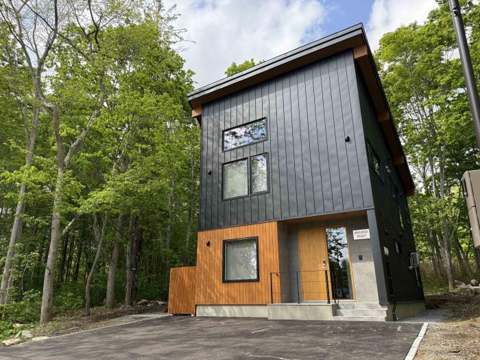 The exterior of a two story house with black siding
