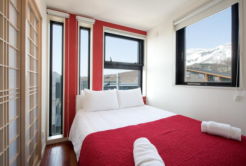 double bedroom with red covers ski view and shoji door
