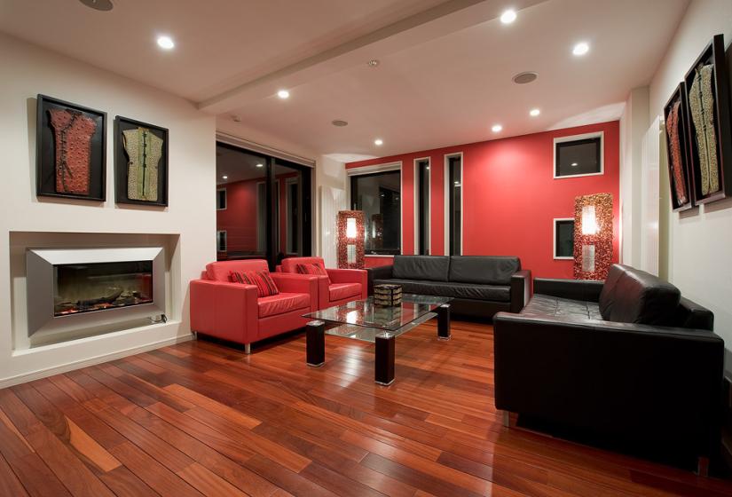 Living area with glass coffee table red and black leather sofa night view