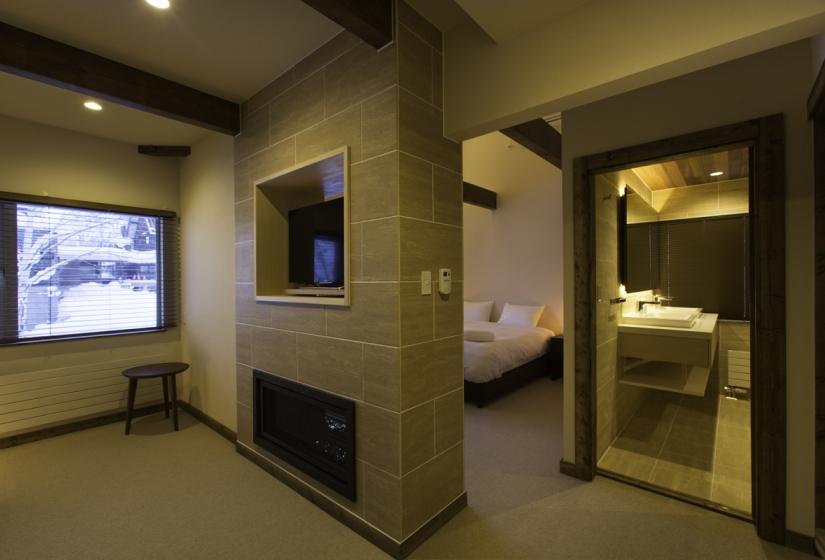 master bedroom with en-suite bathroom, tv, and fireplace 