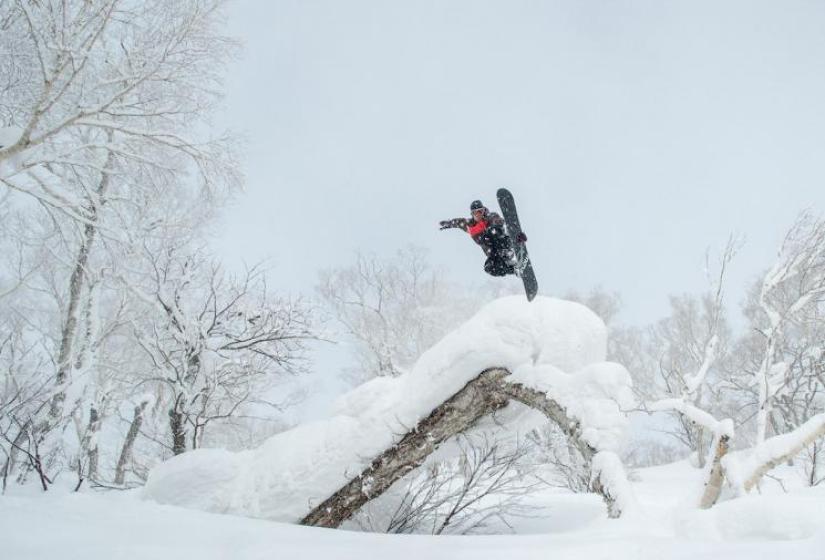 A snowboarder performs a method air