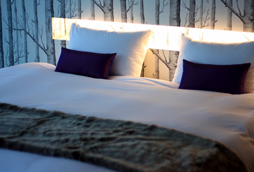 king bed with backlight on wall. tree wallpaper