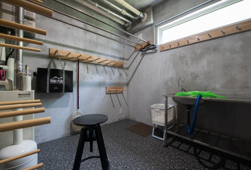 A room with concrete walls and ski racks.