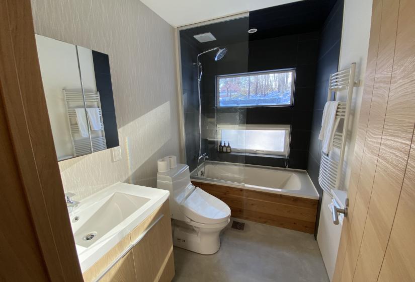 A tiled bathroom, sink, toilet and bathtub