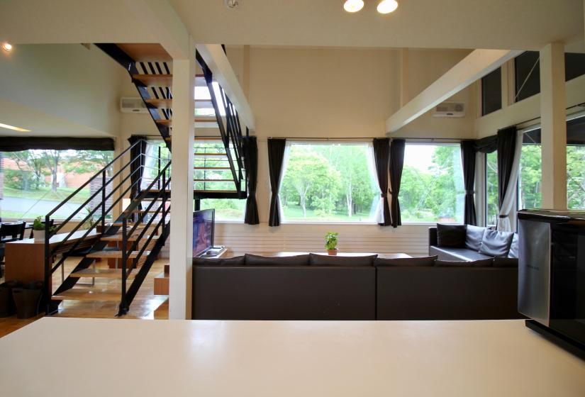 A kitchen bench and black lounge behind