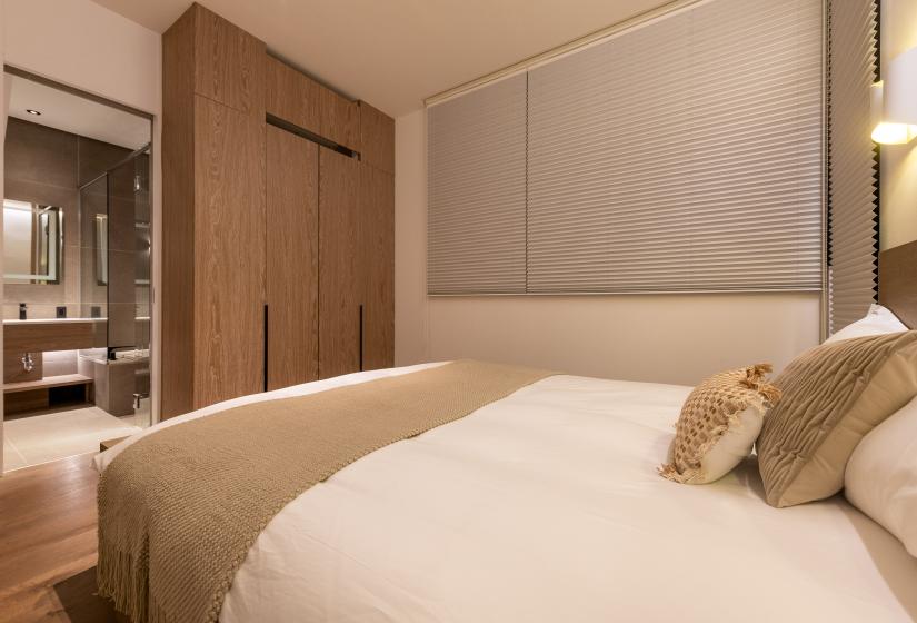 A double bed with brown throw.