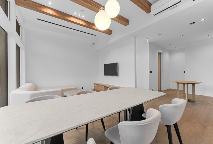 A dining table and lounge behind