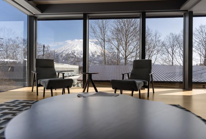 A round coffee table with arm chairs behind